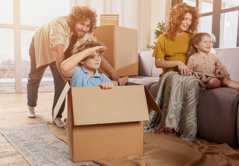 A homebuyer and seller reviewing real estate documents together at a closing table with paperwork and pens.