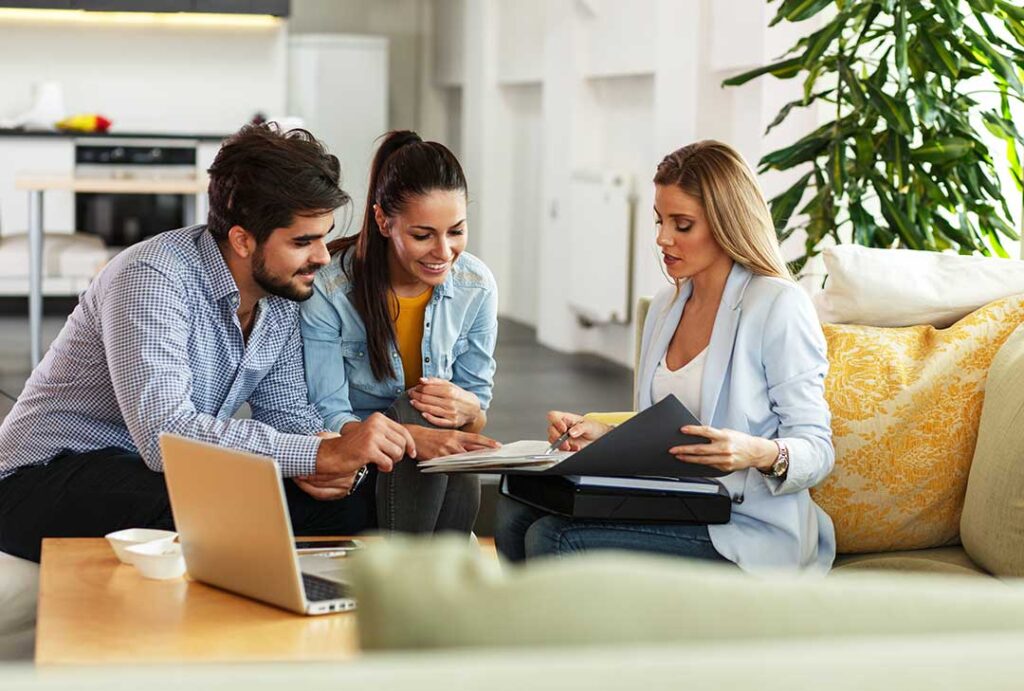 Homeowner reviewing comparable home sales and a pricing worksheet at a kitchen table.